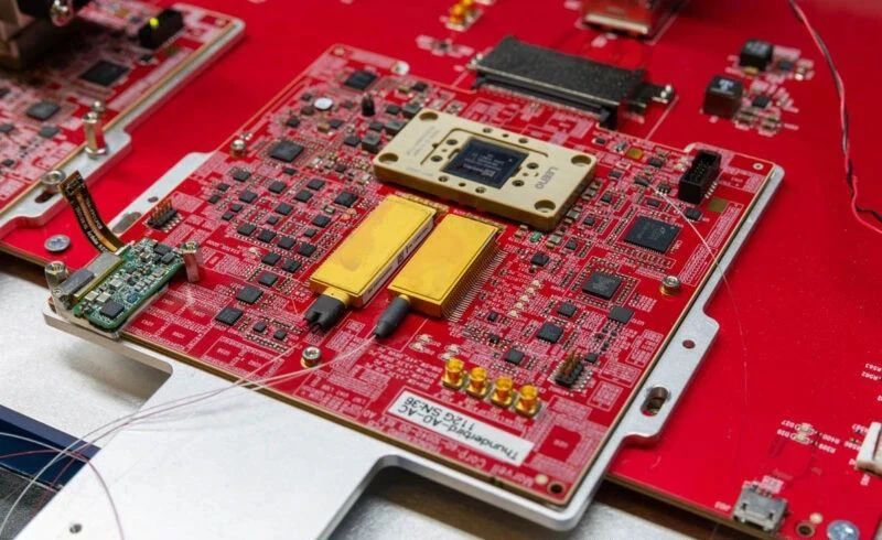 Starting from the DSP, the transmission signal is routed to the CDM, or Coherent Driver Module, which is the smaller of the two golden/brass boxes below, where a single fiber is connected. Starting from the DSP, the transmission signal is routed to the CDM, or Coherent Driver Module, which is the smaller of the two golden/brass boxes below, where a single fiber is connected.