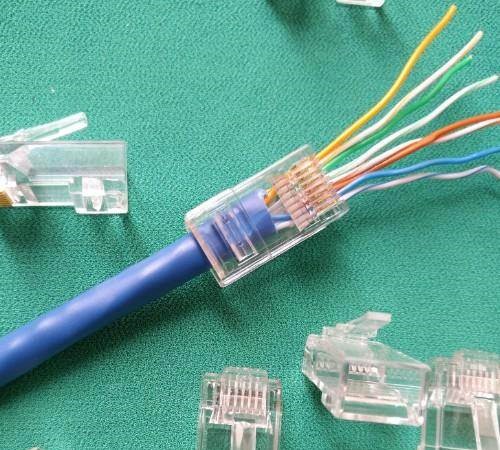  A RJ45 pass through connector is a plastic connector that can be inserted in a fixed direction and secured via a latch mechanism.